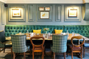 Chic dining area at The Wellington Arms in Hampshire with plush seating and elegant wall art.